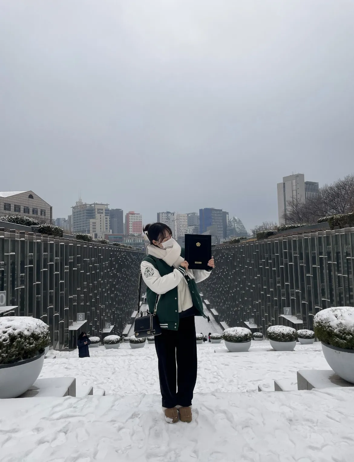 雪の積もった広場で修了証を手にするりんさん