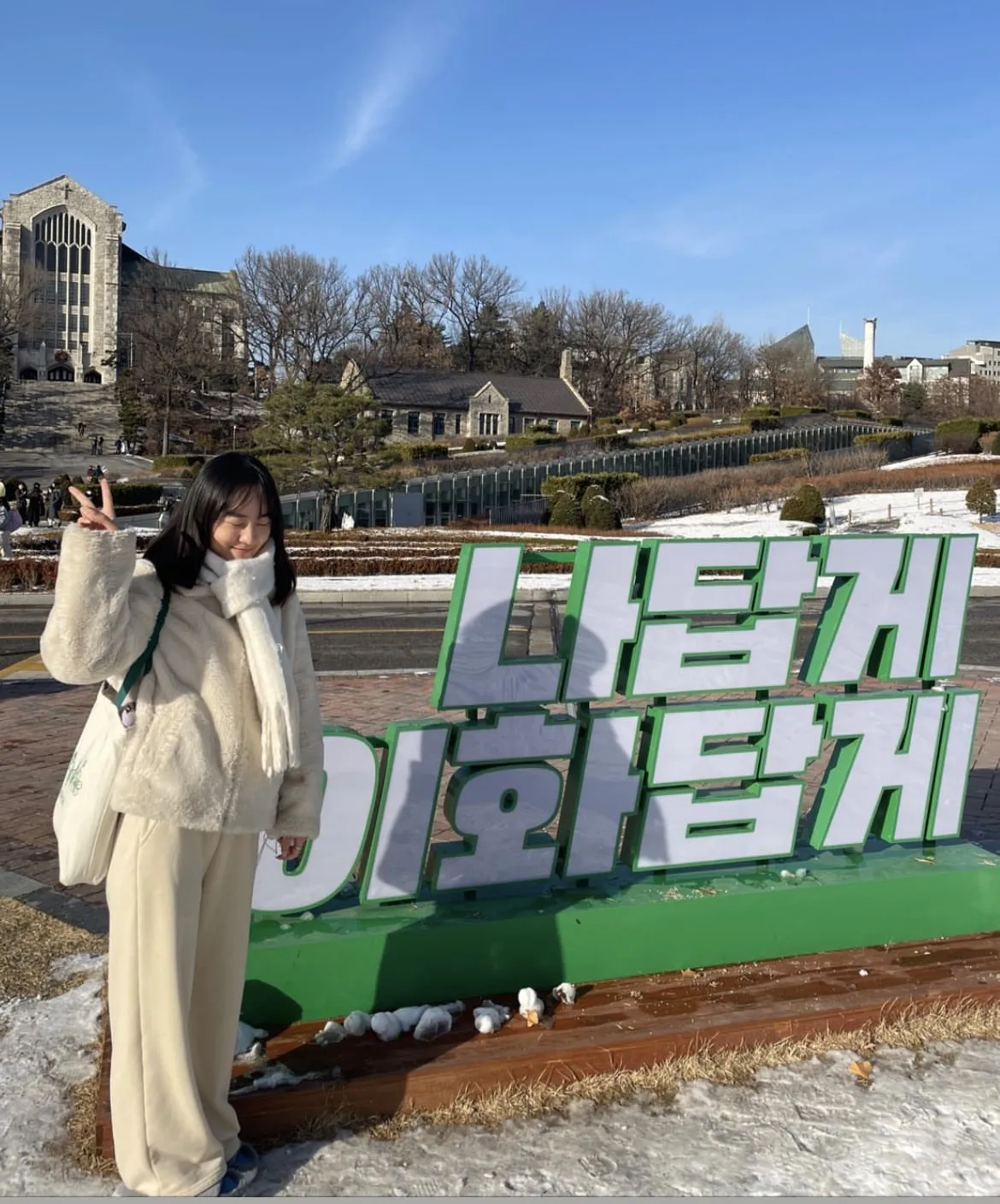 梨花女子大学の看板の前でピースをするりんさん