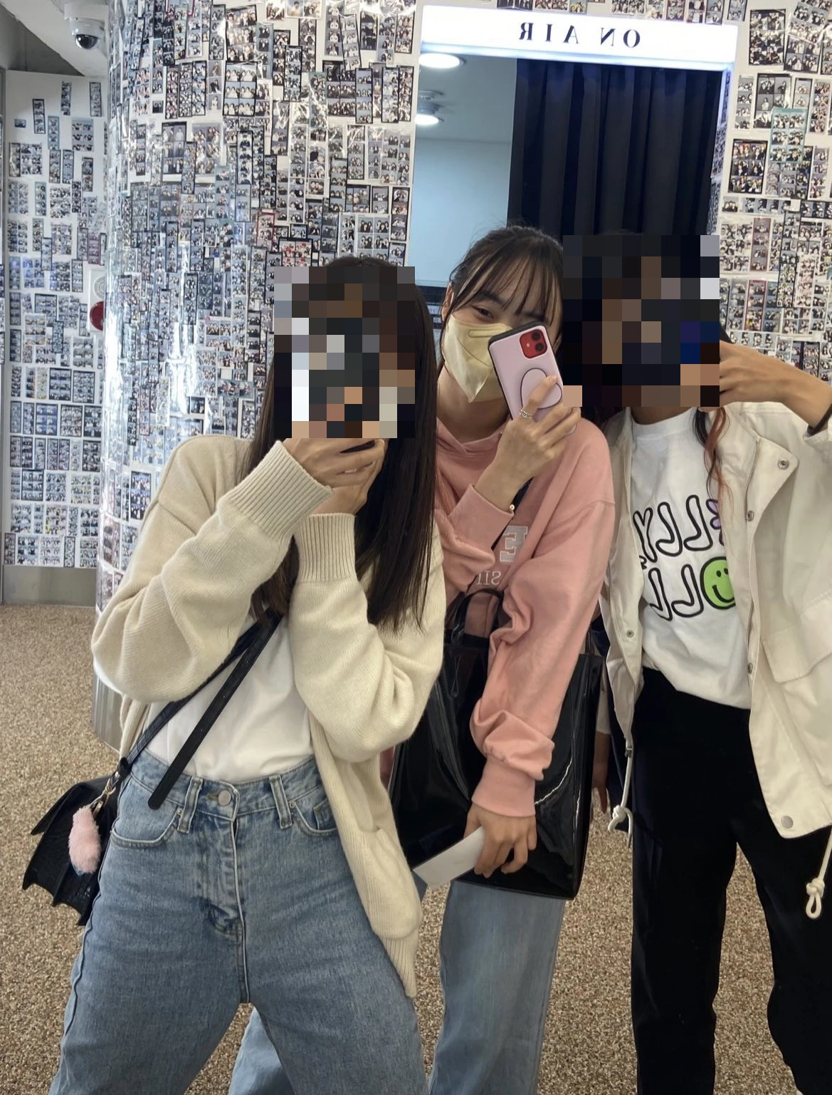 スマートフォンで鏡越しに写真を撮るりんさんと留学生の友達2人