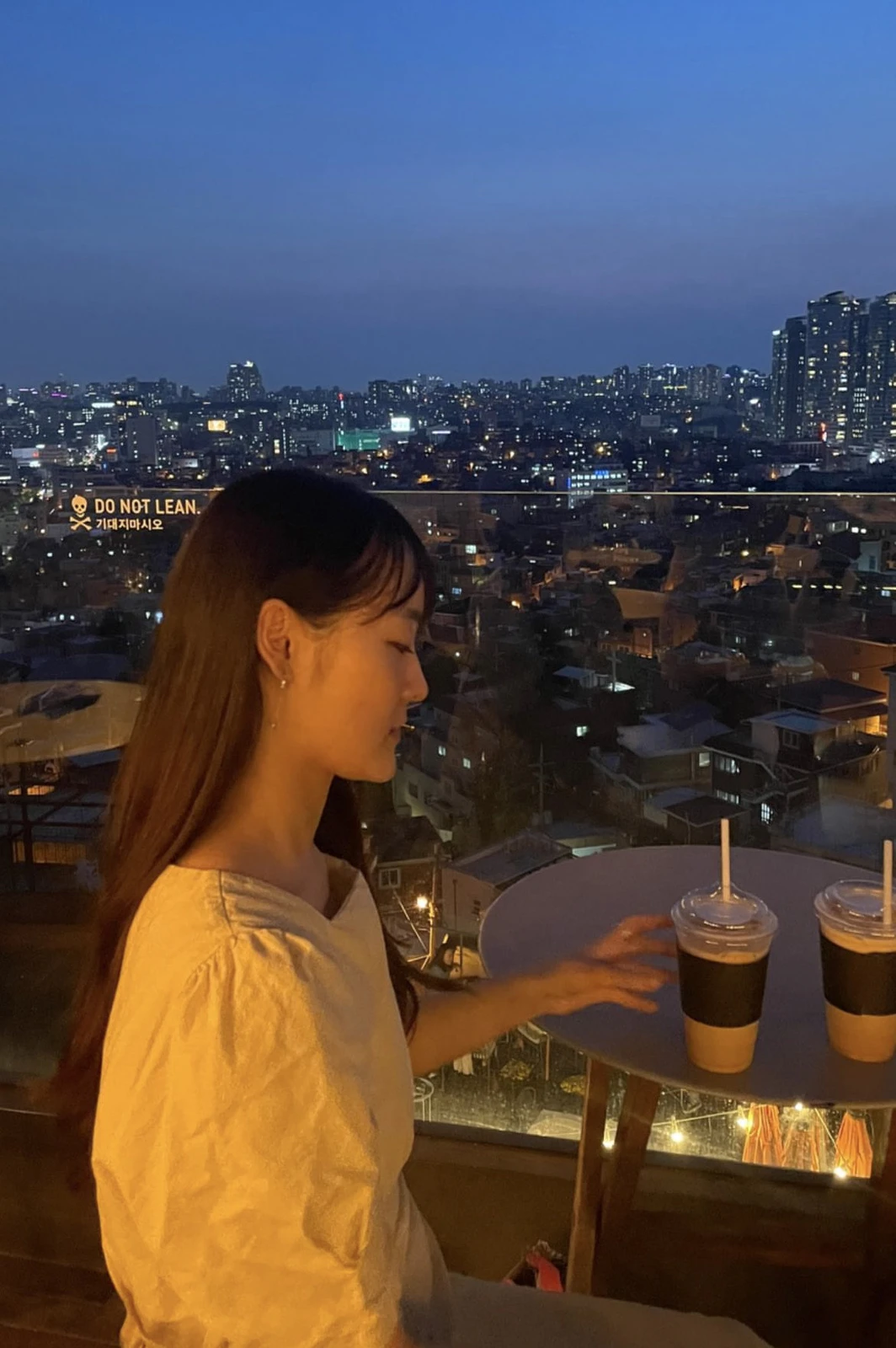 夜景が見える屋上テラスでドリンクを前に座るりんさん