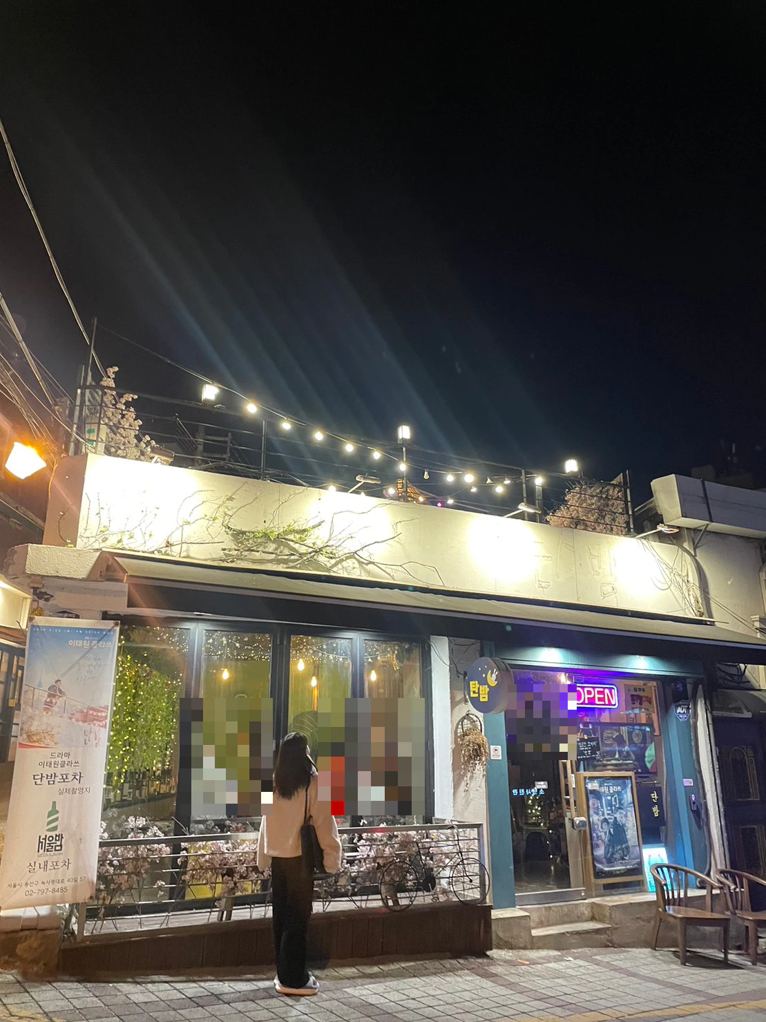 夜の『梨泰院クラス』のロケ地の店の前に立つりんさん