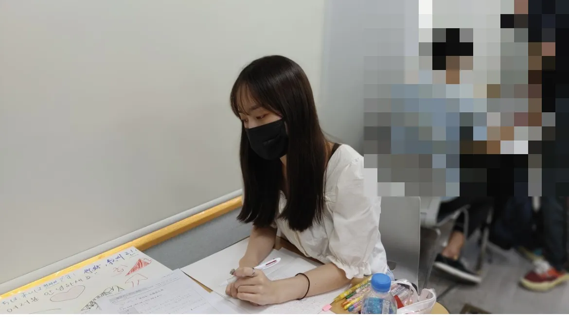 語学学校の教室でプリントに向かうりんさん
